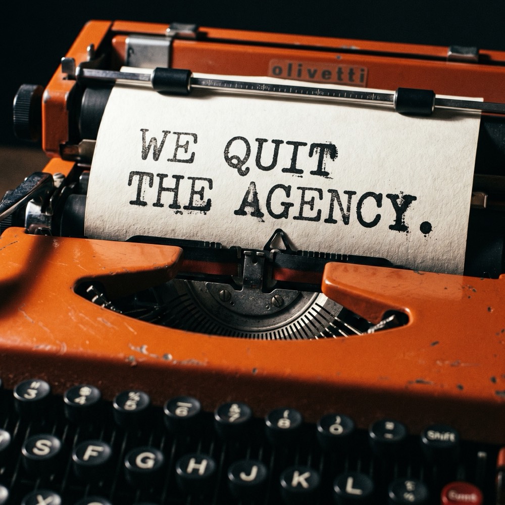 Vintage Olivetti typewriter with a sheet reading WE QUIT THE AGENCY, macro editorial shot